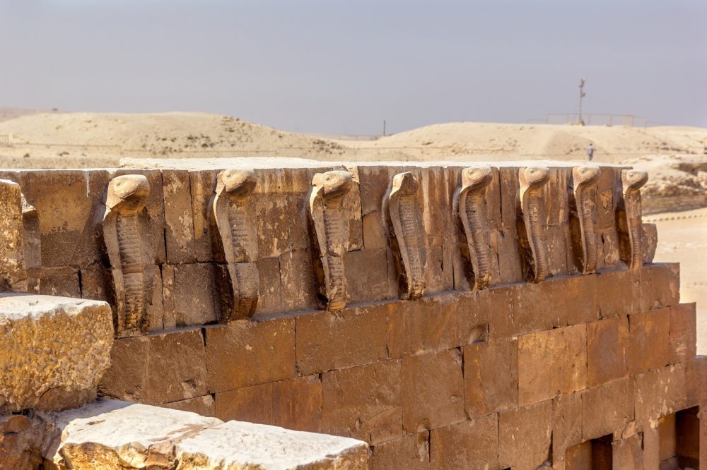 The intricately carved cobras at Saqqara. Shutterstock.