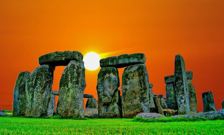 An image of the sun setting behind the stones of Stonehenge. Jumpstory.