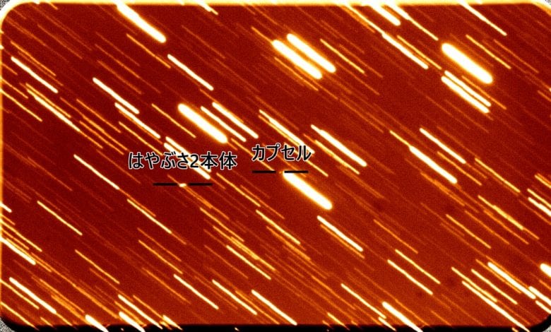In this photograph of space, you see the Hayabusa2 spacecraft on the left as it moves away from the Return Capsule in the middle. Credit: Kyoto University