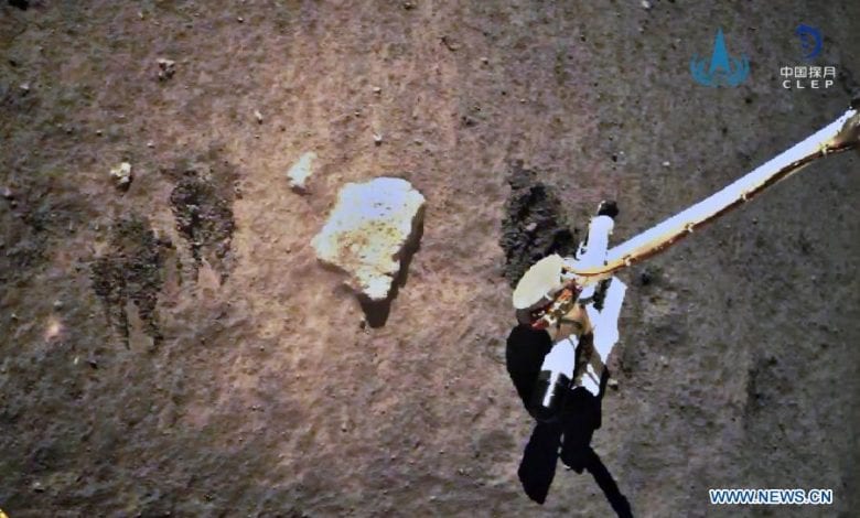 An image showing Chang'e 5 collecting samples on the surface of the Moon. Image Credit: CNSA / Xinhua.