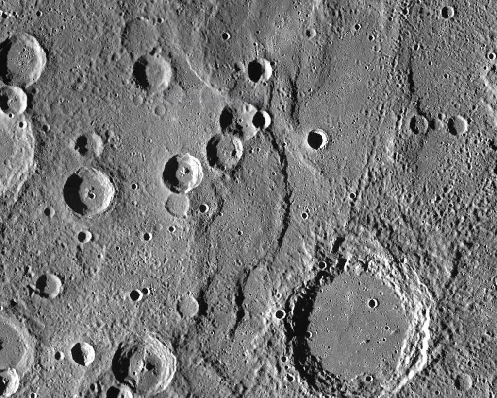 Endeavour Rupes, the shadowed escarpment in the middle of a 400km wide view of Mercury. Image Credit: NASA/JHUAPL/CIW.