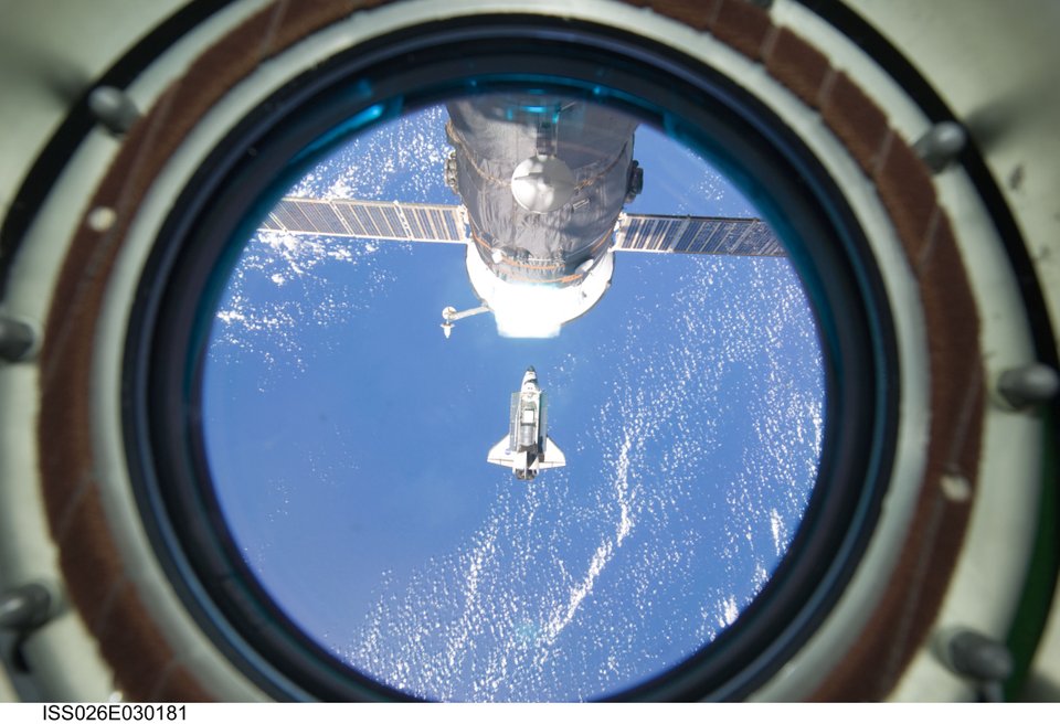 Backdropped by a blue and white part of Earth, space shuttle Discovery is photographed by an Expedition 26 crew member as the shuttle approaches the International Space Station during STS-133 rendezvous and docking operations. Image Credit: NASA.