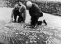 Experts examining the Cochno stone. Image Credit: Royal Commission on the Ancient and Historical Monuments of Scotland.