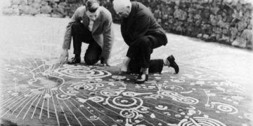 Experts examining the Cochno stone. Image Credit: Royal Commission on the Ancient and Historical Monuments of Scotland.