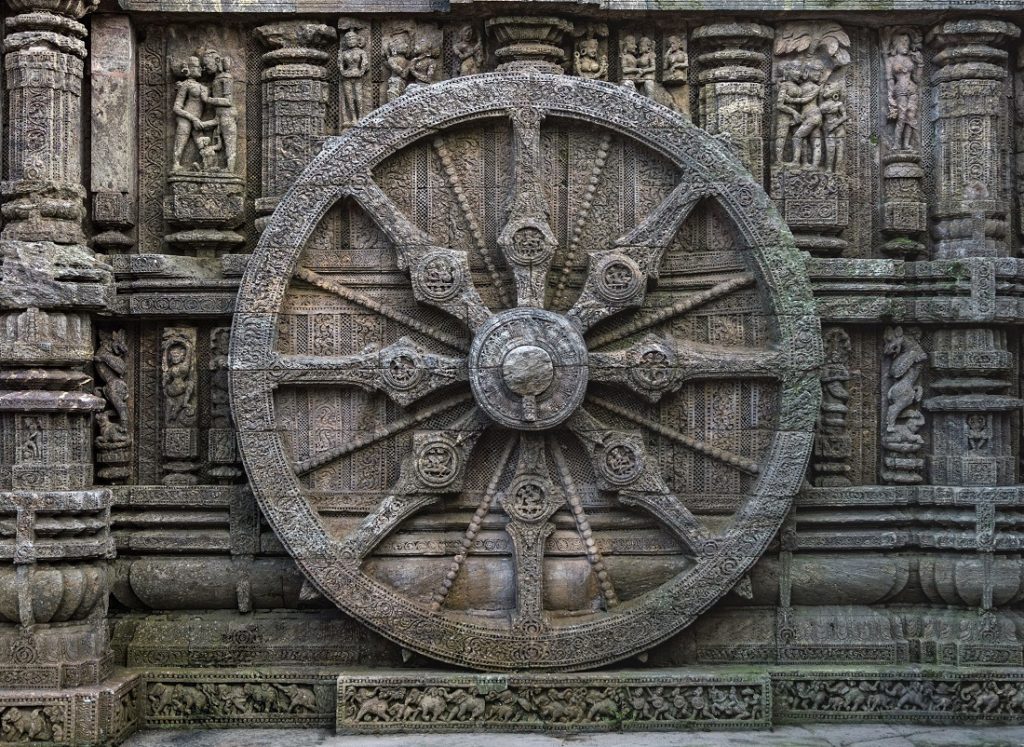 This is a wheel engraved in the 13th century built Konark Sun Temple in Orissa, India. The temple is designed as a chariot consisting of 24 such wheels. Each wheel has a diameter of 9 feet 9 inches with 8 spokes. Each wheel acts as a sun dial and the various engravings shows the daily activity of people at different hours of the day. This is a UNESCO World Heritage site. Image Credit: Wikimedia Commons.