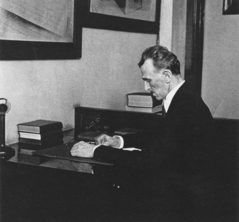 A photograph of Nikola Tesla sitting in his office.