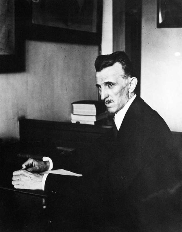 A photograph of Nikola Tesla working in his office in 1916.