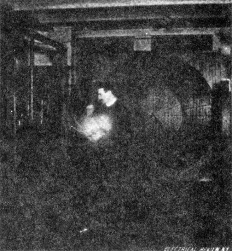 An image of Nikola Tesla lighting a vacuum bulb using waves originating from a distant oscillator.