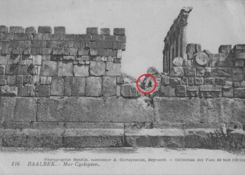 A stunning view of the massive, 1,200-ton block of stone at Baalbek, compared to two people sitting above it.