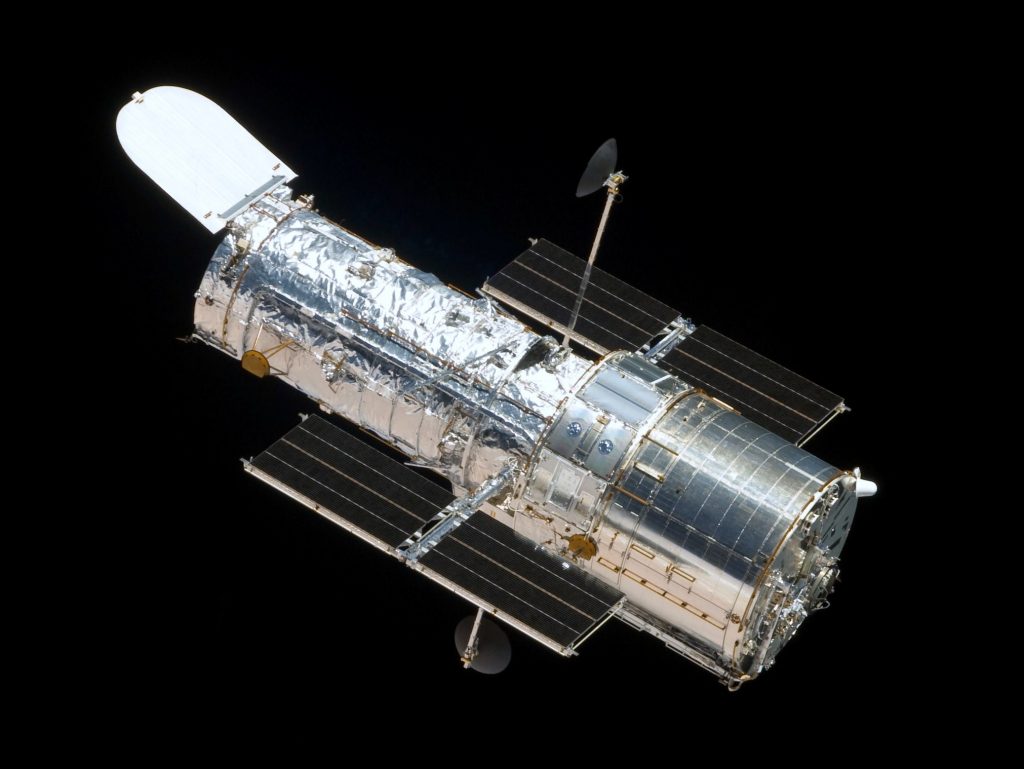 The Hubble Space Telescope in orbit as seen from the departing Space Shuttle Atlantis, flying Servicing Mission 4 (STS-125), the fifth and final Hubble mission. Image Credit: Wikimedia Commons.