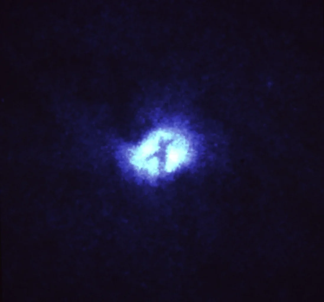 Dark, intersecting dust lanes form an X across the bright nucleus of the Whirlpool Galaxy, M51.