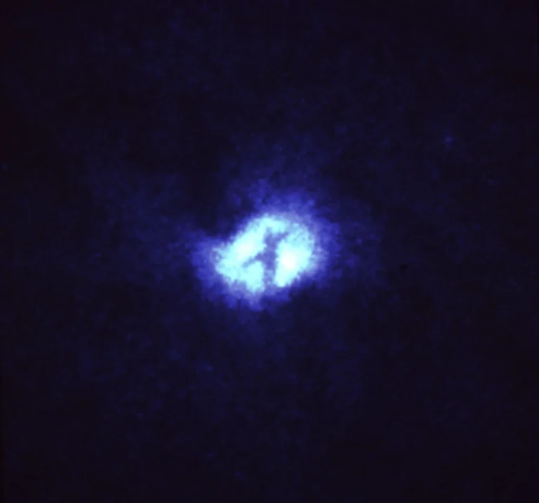 Dark, intersecting dust lanes form an X across the bright nucleus of the Whirlpool Galaxy, M51.