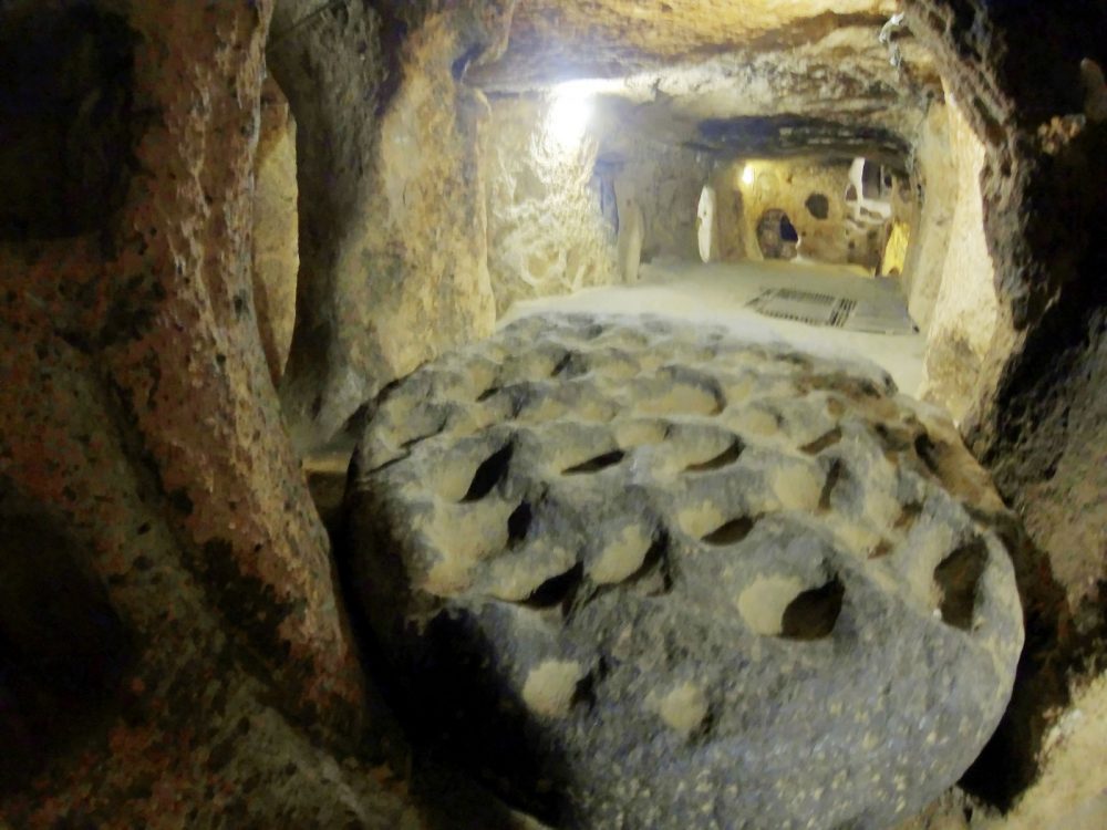 A remarkable block formation of andesite (a volcanic rock) with several holes, used in Kaymakli for cold copper processing. Image Credit: Wikimedia Commons.