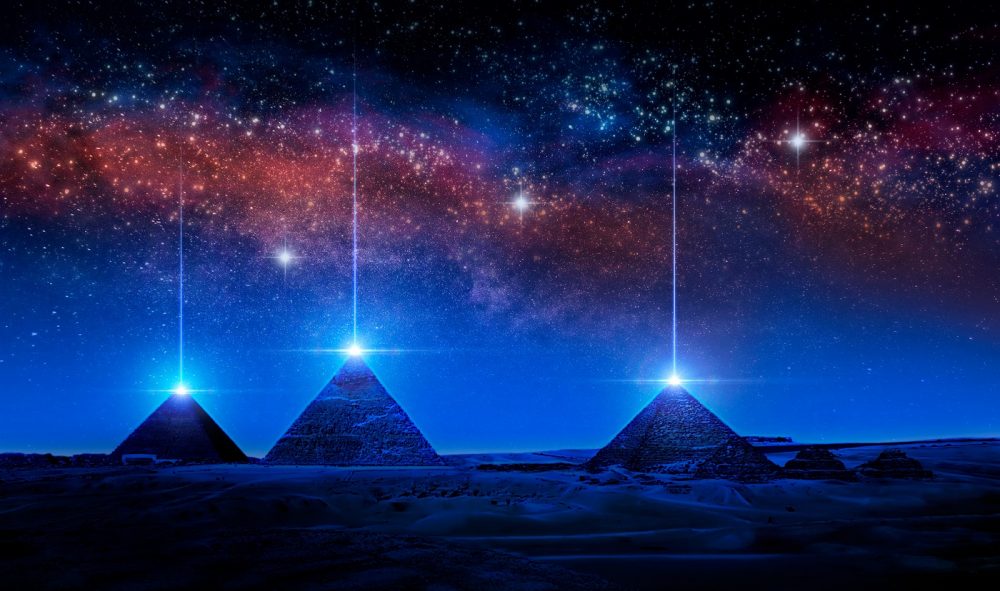 An artists illustration of pyramids with a glowing pyramidion. Shutterstock.