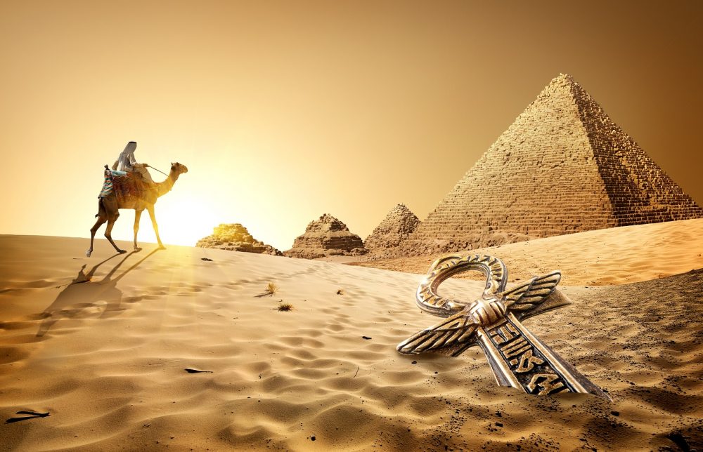 Camel rider, the Pyramids, and an ancient treasure in the sand. Shutterstock.