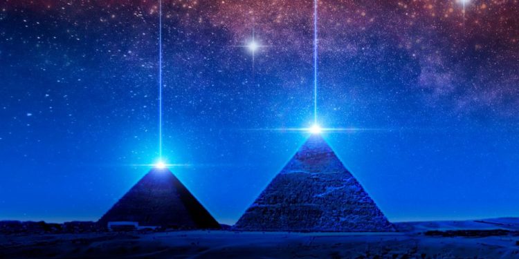 Pyramids and light above the night sky. Shutterstock.