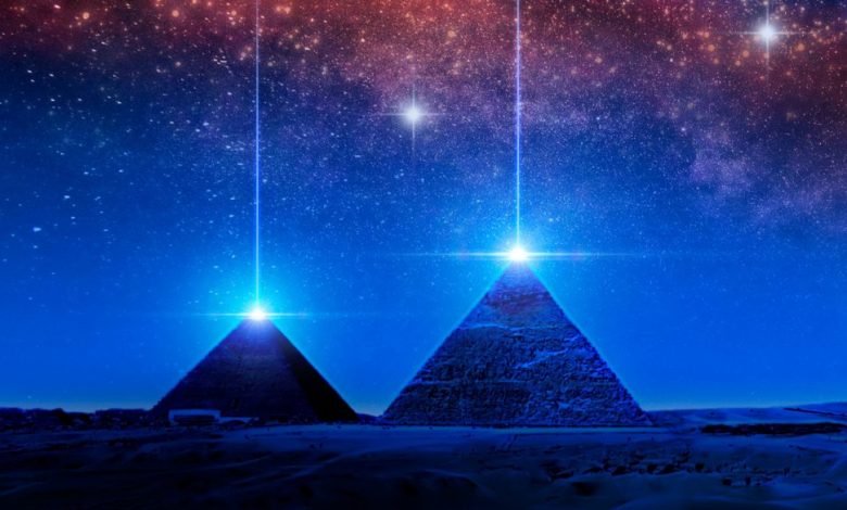 Pyramids and light above the night sky. Shutterstock.