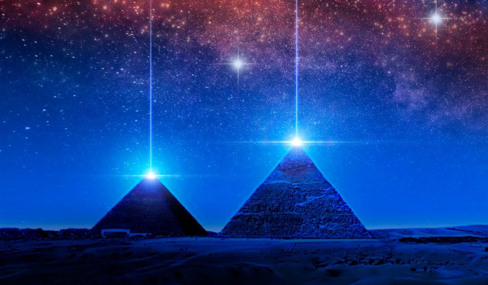 Pyramids and light above the night sky. Shutterstock.