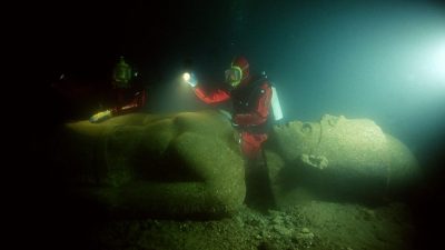 Image showing a diver next to one of the massive statues that now lie submerged in the ancient city of Thonis-Heracleion, at the mouth of the Nile River. Image Credit: Franck Goddio / Hilti Foundation / University of Oxford.