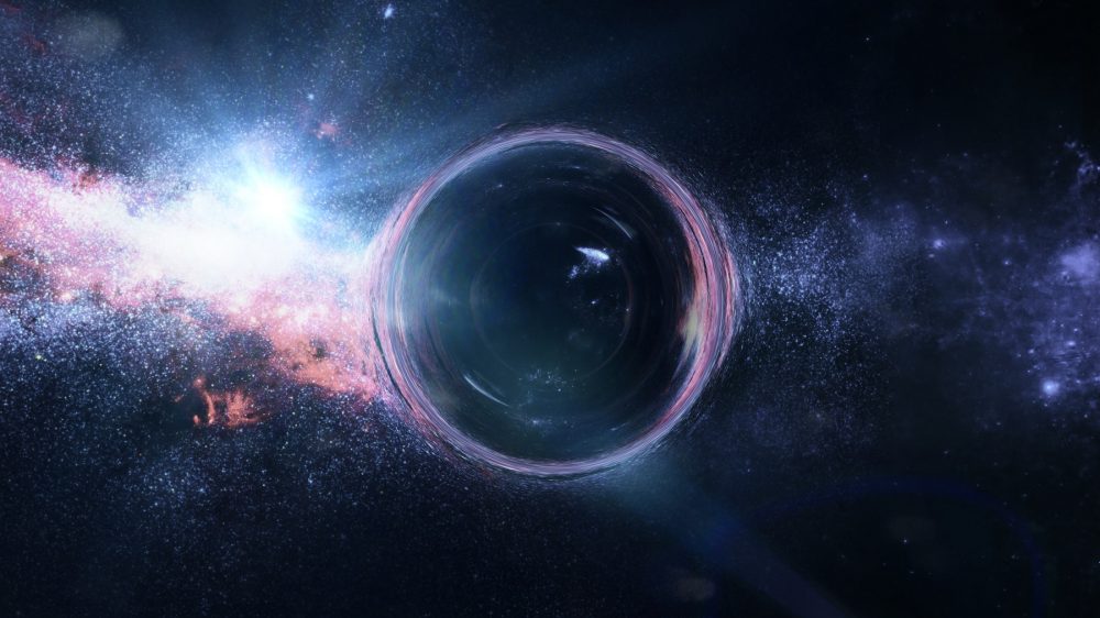 An artist's rendering of a black hole with gravitational lens effect in front of bright stars. Shutterstock.