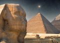 An image showing the The Sphinx, the Great Pyramid and Khafre's Pyramid with the night sky in the background. Shutterstock.