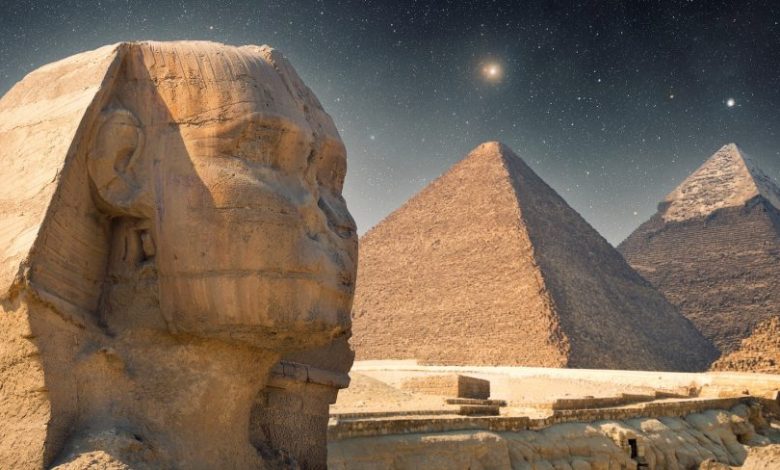 An image showing the The Sphinx, the Great Pyramid and Khafre's Pyramid with the night sky in the background. Shutterstock.