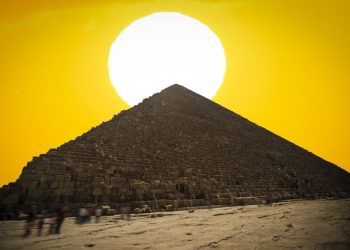 An image of the Great Pyramid of Giza with the Sun in the background. Shutterstock.