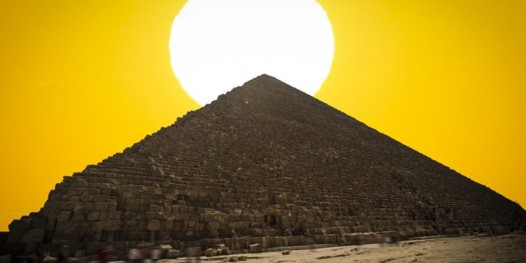 An image of the Great Pyramid of Giza with the Sun in the background. Shutterstock.