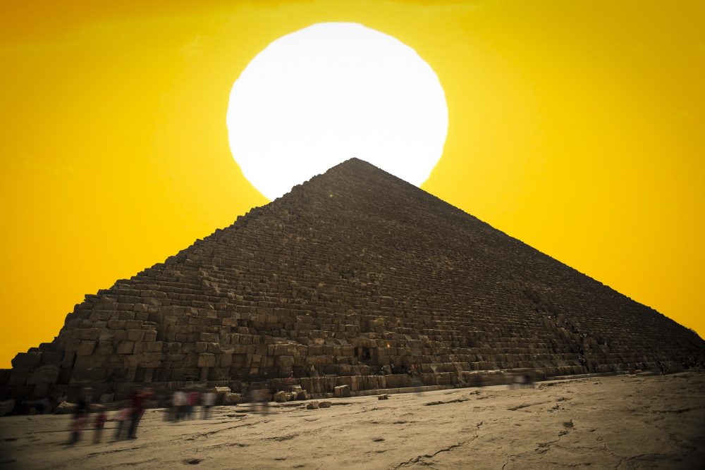 An image of the Great Pyramid of Giza with the Sun in the background. Shutterstock.