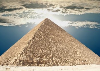 The Great Pyramid of Giza and people climbing its supermassvie stones. Shutterstock.