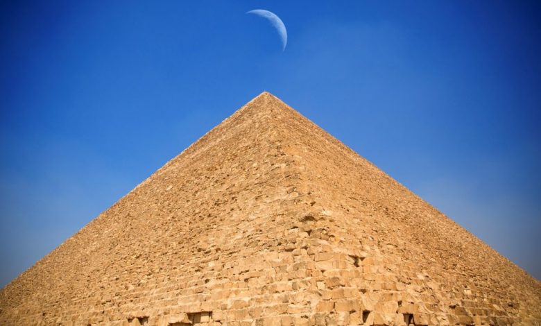 The Great Pyramid of Giza and the moon hovering above its summit. Shutterstock.
