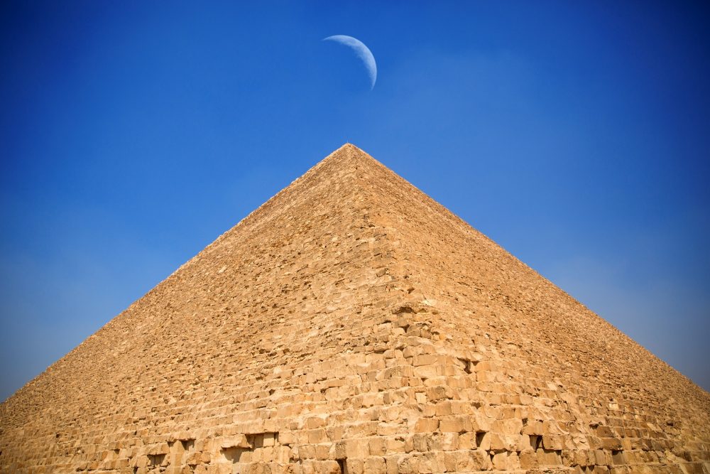 The Great Pyramid of Giza and the moon hovering above its summit. Shutterstock.