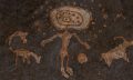 An image of cave art depicting a humanoid with spheres and depictions of what may be animals. Shutterstock.