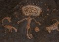 An image of cave art depicting a humanoid with spheres and depictions of what may be animals. Shutterstock.