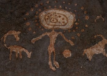 An image of cave art depicting a humanoid with spheres and depictions of what may be animals. Shutterstock.