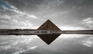An image of an ancient Egyptian pyramid and its reflection. Shutterstock.