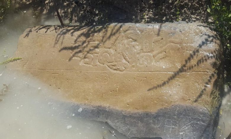 An image showing a half-submerged stone with inscriptions that are thought to date back to the 8th century BC. Image Credit: James Osborne / University of Chicago.