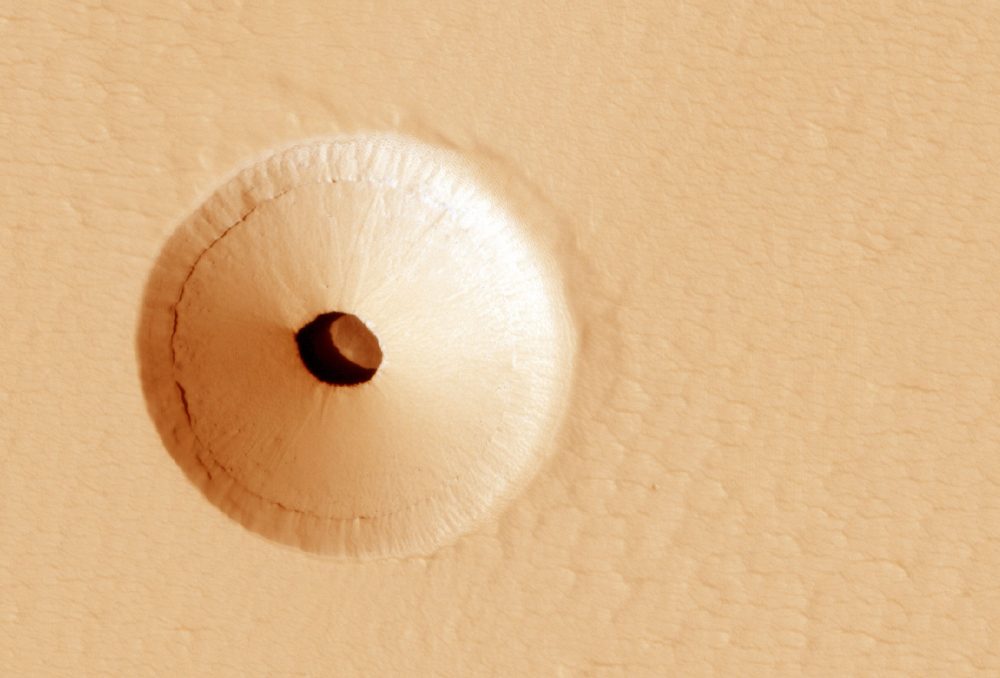 A NASA image showing a mysterious hole on the surface of Mars. Image Credit: MRO / NASA.