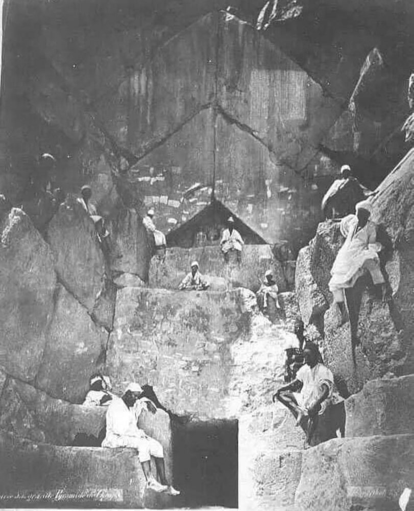 People standing and sitting on the massive stones that make up the entrance to the Pyramid. Image Credit: Public Domain.