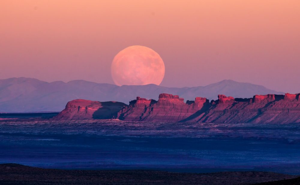 A photograph of the Supermoon rising over Monument Valley. Shutterstock.