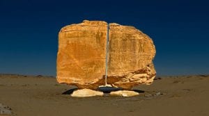 A unique view of the Al Naslaa Rock formation that appears to be split in half with laser like precision. Shutterstock.