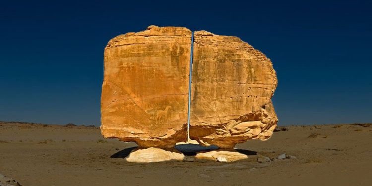 A unique view of the Al Naslaa Rock formation that appears to be split in half with laser like precision. Shutterstock.