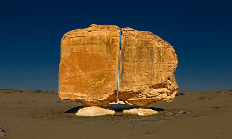 A unique view of the Al Naslaa Rock formation that appears to be split in half with laser like precision. Shutterstock.