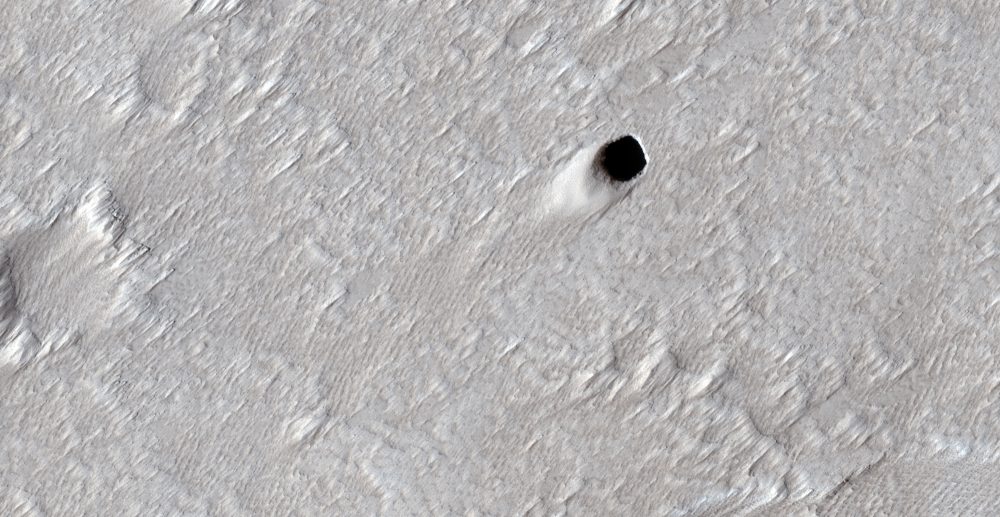 An image of the massive lava tube measuring approximately fifty meters in diameter photographed by the MRO as it flew over the Arsia Mons region on Mars. Image Credit: NASA/JPL/UArizona.