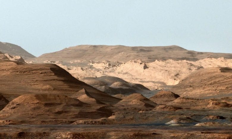 False-color image of Mount Sharp from inside the Gale Crater showing the everchanging planetary environment. Note that the sky is not blue on Mars but it was done deliberately to enhance the researchers' ability to distinguish the different stratification layers. Credit: NASA/JPL