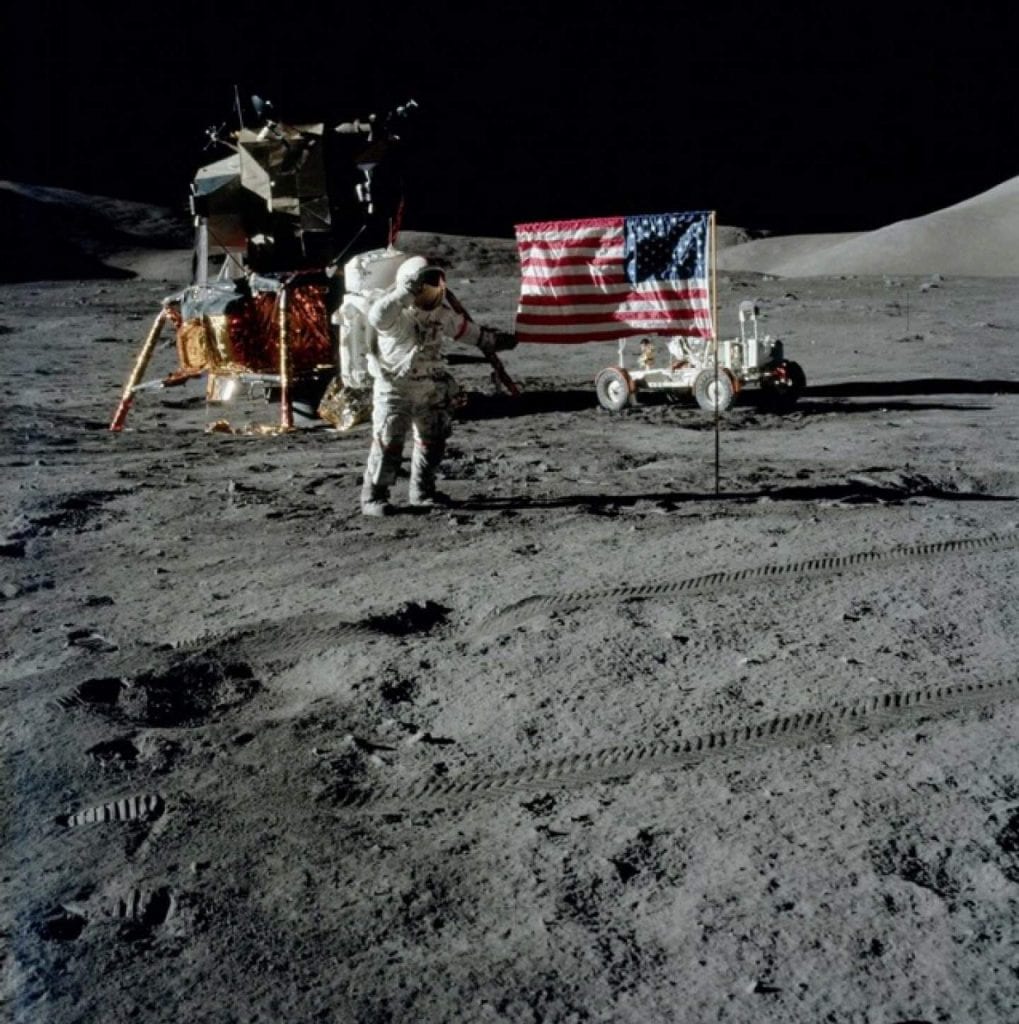 An image of Apollo 17 Commander Gene Cernan with the American flag during Apollo 17. Credit: Smithsonian National Air and Space Museum / NASA