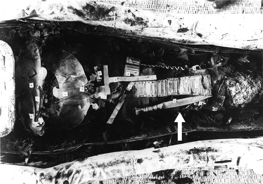 The arrow shows King Tutankhamun's dagger as it was discovered placed on his right thigh. Credit: Griffith Institute, University of Oxford
