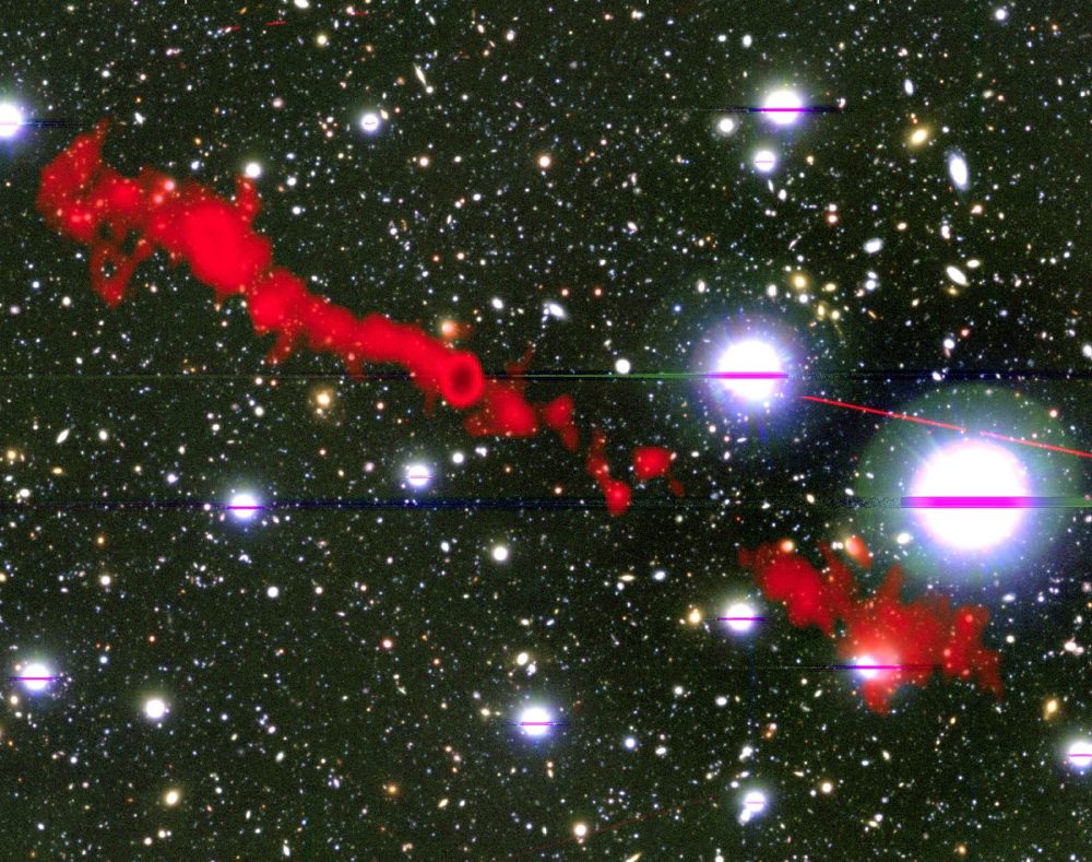 In this image, you can see one of the giant radio galaxies (MGTC J100016.84+015133.0) in red and a cosmic background as you would see it in optical light. Credit: I. Heywood, University of Oxford / Rhodes University / South African Radio Astronomy Observatory / CC BY 4.0.