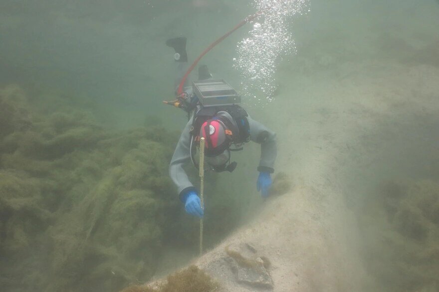 An underwater archaeologist exploring the site of the newly found ancient settlement in Lake Lucerne. Credit: Unterwasserarchäologie UWAD Zürich/Canton Lucerne