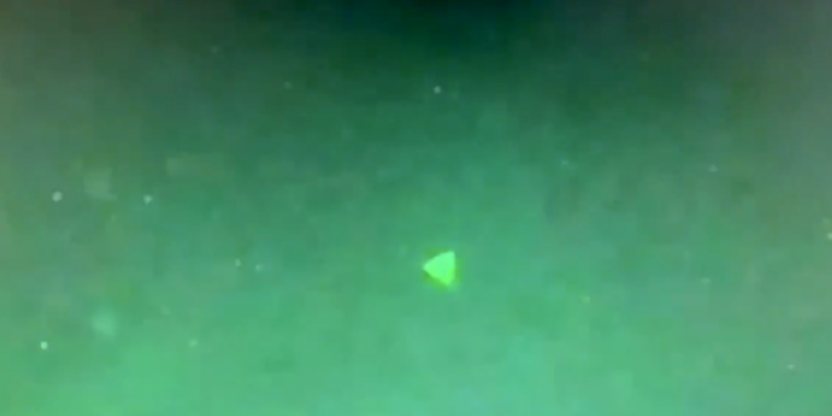 A screenshot of the video allegedly showing a pyramid-shaped UFO hovering above a US Navy ship. Image Credit: Jeremy Corbell / Twitter.